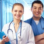 یک پزشک و یک پرستار در کنار یکدیگر ایستاده و لبخند زدهاند