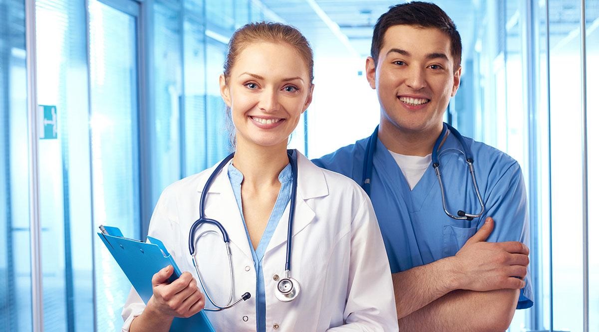 یک پزشک و یک پرستار در کنار یکدیگر ایستاده و لبخند زده‌اند