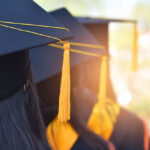 چند شخص که لباس فارغالتحصیلی پوشیده و در صف ایستادهاند